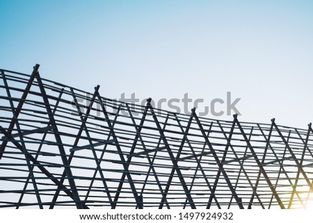 Traditional Norwegian wooden rack for drying cod fish with airplane visible flying in sky