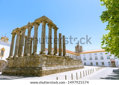 Dianna Temple and cathedral tower in Evora. Ancient roman temple in the old city of Evora, Portugal Royalty-Free Stock Photo #1497925574
