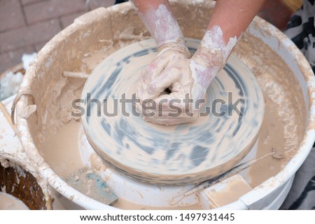 Potter forming clay on the pottery wheel.