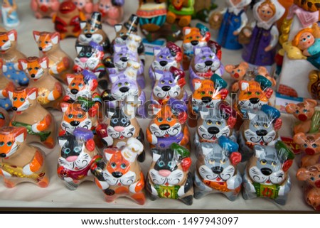 Clay figures painted with bright colors Dogs Cats Foxes Pigs. Selective focus. Folk art is a Decorative art.