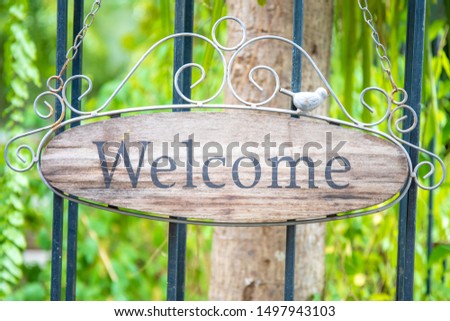 Welcome sign on the iron door or fence. made from wooden.