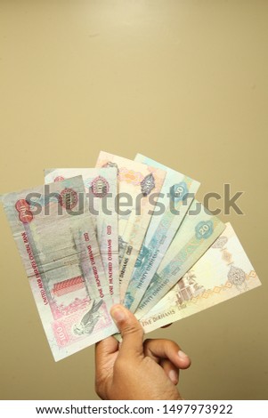 Currency of United Arab Emirates ( Dirham ) with a light gold background