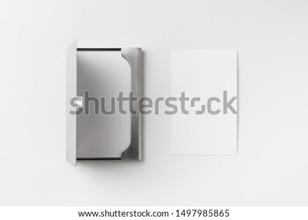 Design concept - top view of vertical business card with stainless steel case isolated on white background for mockup, it's real photo, not 3D render