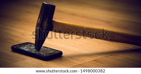 smartphone smash with a hammer. the concept of loss data. broken smart phone on wooden surface.
