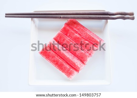Set of crab sticks with wood chopsticks on white plate, stock photo