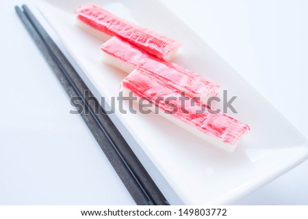 Crab sticks group with chopsticks on white background, stock photo