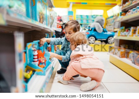 Little boy and girl at the shelf in kids store Royalty-Free Stock Photo #1498054151