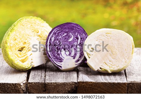 Savoy cabbage, red cabbage and white cabbage on wooden board