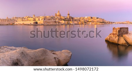 Panoramic view of Valletta Skyline with churches of Our Lady of Mount Carmel and St. Paul's Anglican Pro-Cathedral at sunset as seen from Sliema, Valletta, Capital city of Malta