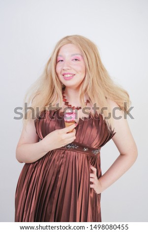 Girl eating ice cream and looking cute on white studio background. happy excited expression portrait of Multicultural Asian young woman model.