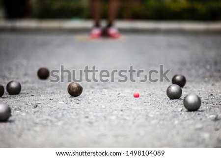 Petanque ball boules and small red jack on petanque field, Man playing petanque Royalty-Free Stock Photo #1498104089