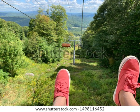 Feet with Red shoes hanging off Gondola and other Gondola rides in picture frame, concept picture of having vacation time