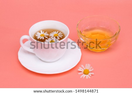 Tea with camomile in a white cup and a transparent bowl with honey. Phytotea, healthy lifestyle