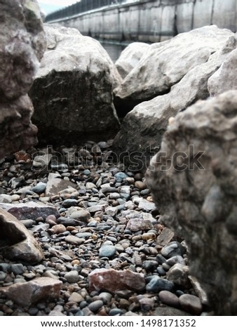 Closeup picture of a pile of grey stones with a lot of solid rocks around