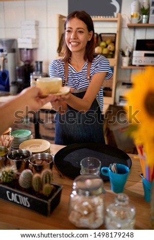 smiling woman barista at workplace at new open cafe store.
