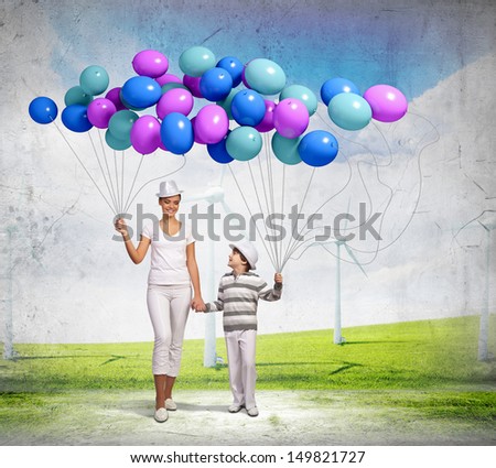 Image of mother and son holding bunch of colorful balloons