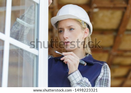 woman builder unscrews fastening screws handle window Royalty-Free Stock Photo #1498223321