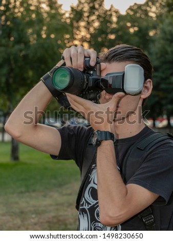 A young photographer takes pictures in the park,a young photographer learns to use a camera
