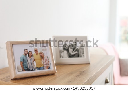 Family portraits in frames on cabinet indoors
