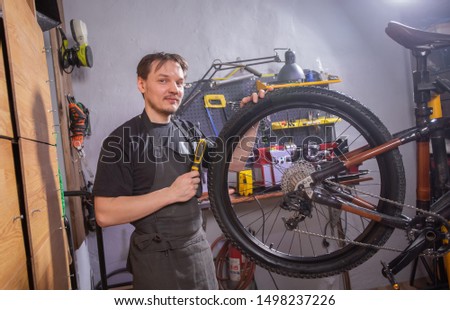 Service, repair, bike and people concept - Mechanic repairing a mountain bike in a workshop