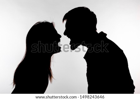 Aggression and abuse concept - man and woman expressing domestic violence in studio silhouette isolated on white background. Royalty-Free Stock Photo #1498243646