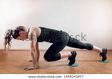 Sportswoman exercising, using Gliding Discs.