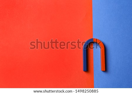 Red and blue horseshoe magnet on color background, top view. Space for text