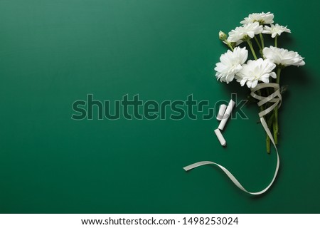 Flat lay composition with flowers on green chalkboard, space for text. Teacher's day