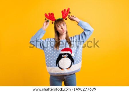 Photo of very funny making faces squinting eyes see her nose teen hipster in retro big jumper jeans playing with toy decoration on red horns isolated bright color background