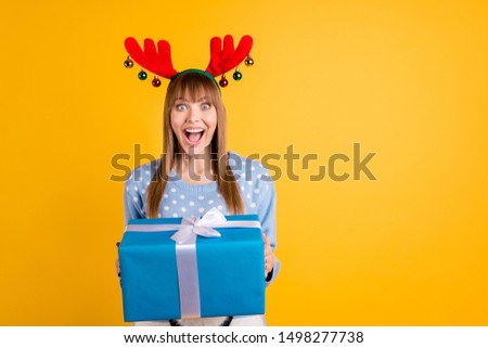 Giftbox from secret Santa concept. Photo of cheerful screaming celebrating optimistic with astonished facial expression hipster holding large wrapped package in hands isolated vivid color background