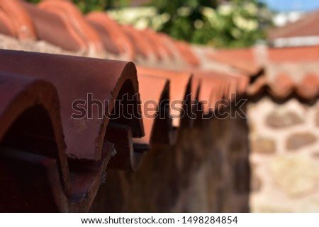 Roof tiles on the ancient stone walls.