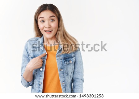Pleased surprised nice asian girl receive unexpected flattering offer pointing herself ambushed index finger touch chest wondered smiling broadly look camera questioned standing white background