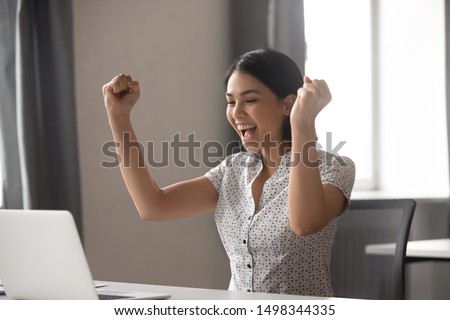 Excited young asian business woman celebrating successful financial project results, attracting important corporate client, dream goal achievement. Euphoric employee got increased salary or promotion. Royalty-Free Stock Photo #1498344335