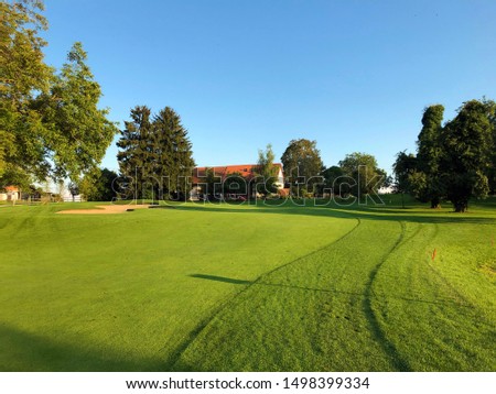 Beautiful lawns lighted by the late afternoon sun in the village of Oberwil bei Nuerensdorf - Canton of Zurich, Switzerland / Golf course Breitenloo or Golfplatz Breitenloo, Oberwil bei Nürensdorf