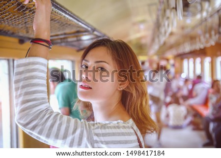 Picture of an Asian woman traveling back to his home by an old train.Focus on face