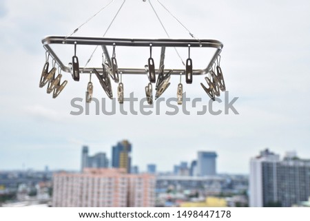 Clothespin to hang for clothes behind a tall building overlooking the city and the sky.