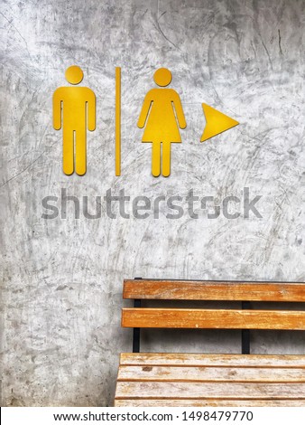 Toilet sign in front of restroom with a bench, concept background