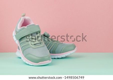 Fashionable gray sneakers on a blue and pink background. Sports shoes.