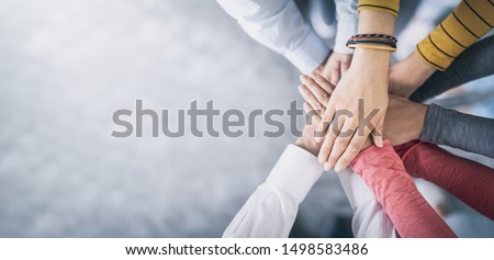 Close up top view of young business people putting their hands together. Stack of hands. Unity and teamwork concept. Royalty-Free Stock Photo #1498583486