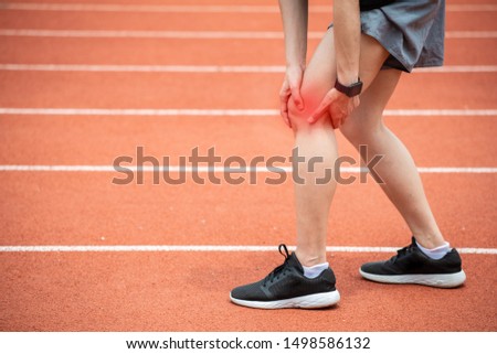 Close up of runner woman holding her leg, suffuring from ITB Syndrome caused by altered running biomechanics due to underlying muscular imbalances. Royalty-Free Stock Photo #1498586132