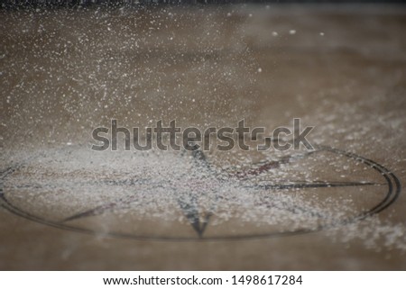 The quick shutter shot of the caram Powder falling on the carrom board....