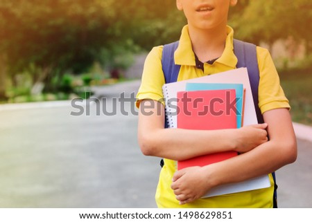 Books and notebooks in the hands of a child