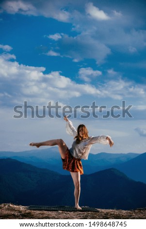 Passionate young woman dancer in a beautiful dreamy pose with one leg up in the air