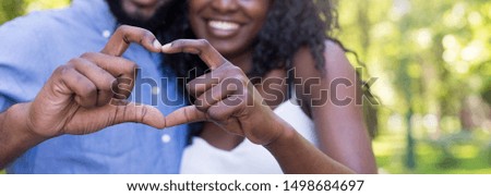 Cropped close up of couple making heart shape with hands