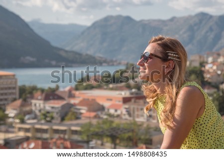 Portrait of happy woman who enjoy the view on mountaints and Kotor Bay.