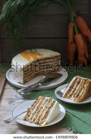 Carrot cake, pieces of cake with curd cream and carrots on a wooden background. Rustic style.