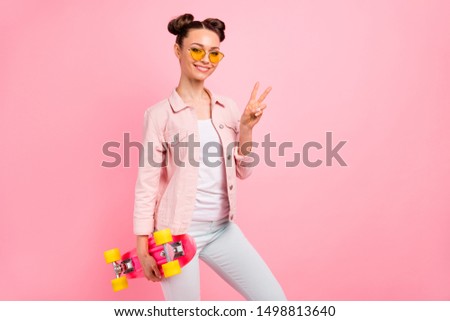 Portrait of cheerful lady making v-signs wearing jacket isolated over pink background