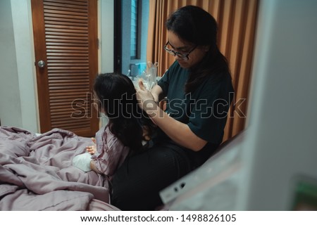 Portrait of girl patient and mother comb hair in hospital childrens ward.