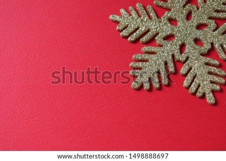 Christmas decoration - snowflake in gold sparkles on a festive red background