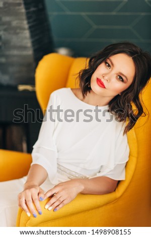 Fashion portrait of beautiful young asian woman wearing white dress, sitting on the chair